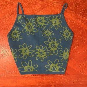 Blue cropped tank top with green flower pattern.